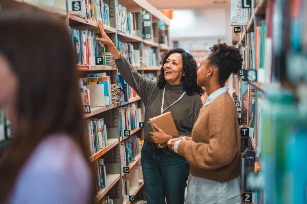 istock Hispanic Student Searching For A Book With A Librarian 1455947927