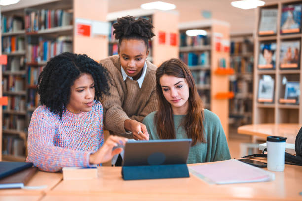 istock Diverse Females Using Laptop In A Library 1455948102
