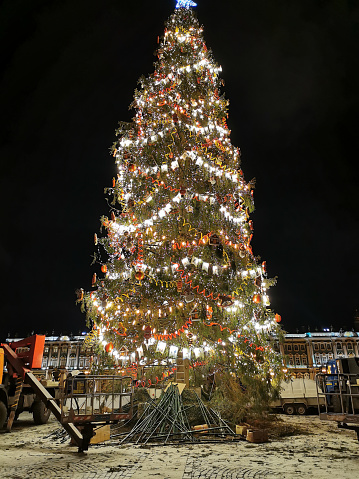 Christmas tree on the Palace Square of St. Petersburg, which is finished to collect and decorated in a retro style with serpentine, flags, garlands and toys for Christmas and New Year.