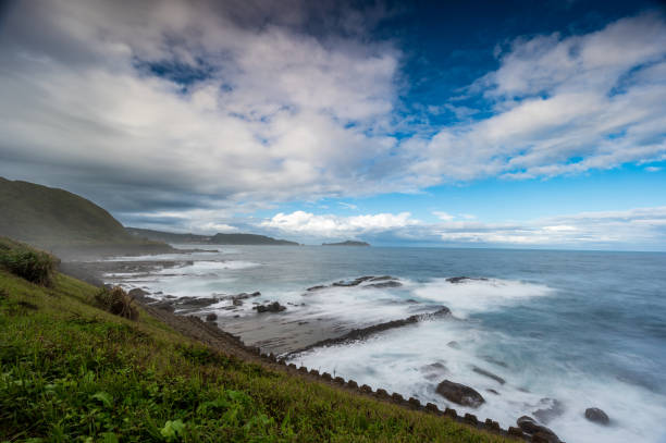 istock Rocky coast under blue sky and white clouds. White waves and light blue sea. 1455949453