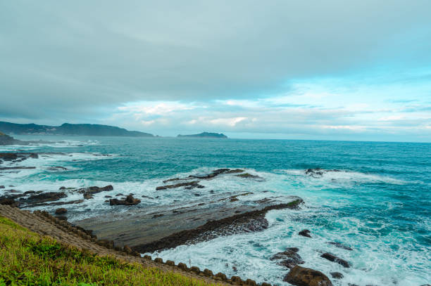 istock Rocky coast under blue sky and white clouds. White waves and light blue sea. 1455949490