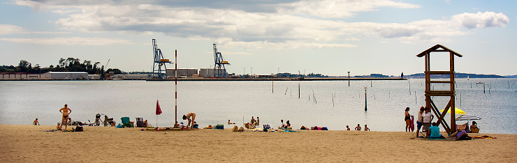 Group of people on beach, lifeguard watchtower silhouette, beach, seascape. Compostela beach, Vilagarcía de Arousa , ría de Arousa, Rías Baixas,Pontevedra province, Galicia, Spain. Copy space available