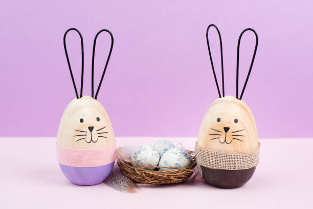 istock Easter bunny or rabbit sitting next to a wicker nest filled with painted eggs, spring holiday card 1455953859