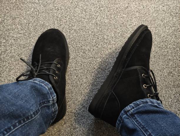istock Black winter suede boots on the feet. First-person view 1455953981