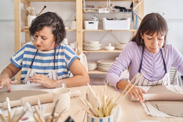 istock Two women working with clay in a pottery workshop. 1455954715