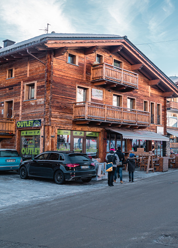 Livigno, Italy – January 12, 2022: A vertical street view of the main shopping street - Via Plan with cars and perfume shop