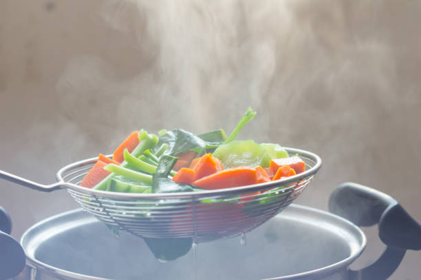 The steam from the vegetable colander in the dark