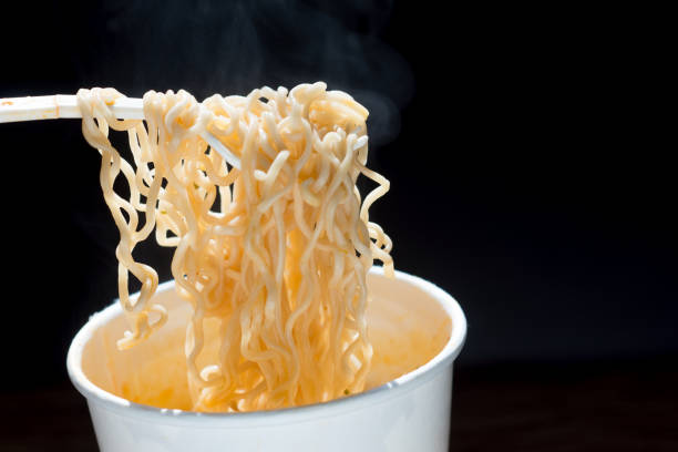 istock Instant noodles cup with plastic fork  is Asia fast food on dark background. 1455955156
