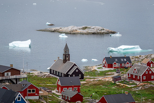 Aerial view of Ilulissat with Zion´s church and icebergs floating in the background, Greenland