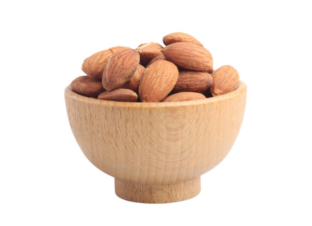 istock Almonds in a wooden cup on a white background 1455958436