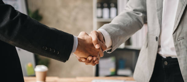 Two confident business man shaking hands during a meeting in the office, success, dealing, greeting and partner in sun light Two confident business man shaking hands during a meeting in the office, success, dealing, greeting and partner business handshake partnership human hand stock pictures, royalty-free photos & images