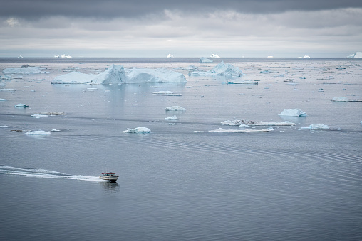 Boat sailing among the icebergs at Ilulissat Icefjord, Greenland