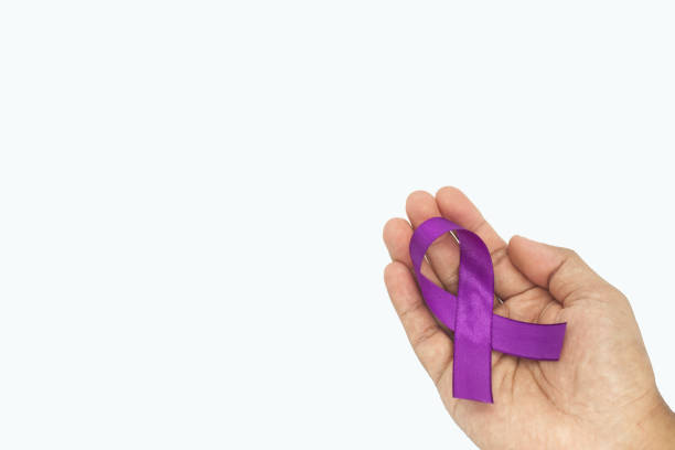 istock Hand holding purple ribbon on white background with copy s 1455964898