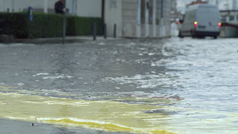 LD Flood barrier on the street of a coastal town and a car driving by