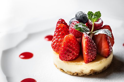 Vanilla New York cheesecake decorated with fresh blueberries and strawberries