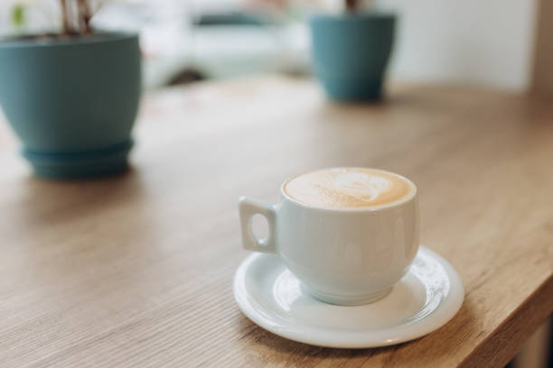 istock Cup of coffee with heart pattern in a white cup on wood table 1455967590