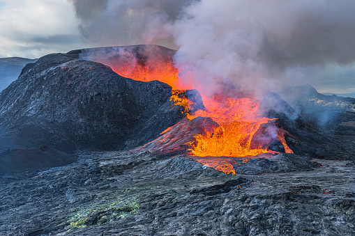 Volcanic landscape in Iceland. glowing lava emerges from volcanic crater. active volcano on Reykjanes Peninsula in GeoPark. Eruption with lava flow and smoke development over the crater