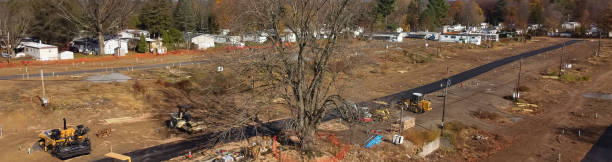 istock Panorama aerial heavy machines foundation, earthmoving works at mobile home park construction site near row of completed manufactured trailer houses in Rochester 1455973523