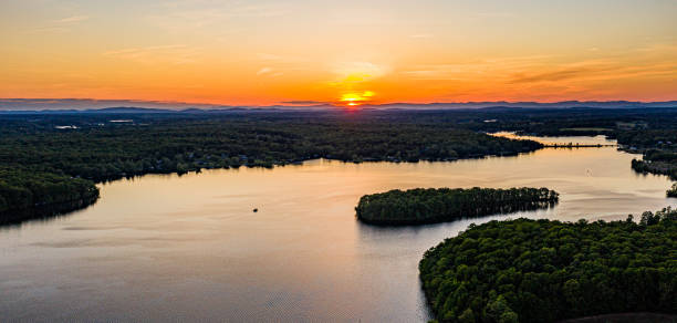 istock Lake in the forest with a yellow sunset and small clouds on the background 1455973755