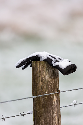 UK, Marlow, December 2022: a lost glove has been placed on a fencepost in the snow.