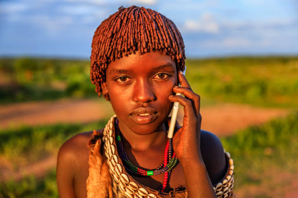 junge frau aus hamer mit smartphone, omo valley, äthiopien, afrika - hamer woman stock-fotos und bilder