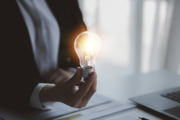 istock Person holding glowing lamp, Creative new idea. Innovation, brainstorming, strategizing to make the business grow and be profitable. Concept execution, strategy planning and profit management. 1455979093