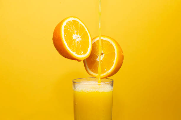 istock pouring juice into a glass from half an orange 1455979094