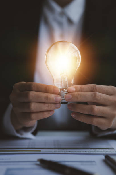 istock Person holding glowing lamp, Creative new idea. Innovation, brainstorming, strategizing to make the business grow and be profitable. Concept execution, strategy planning and profit management. 1455979111