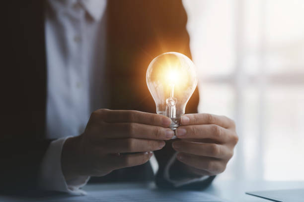 istock Person holding glowing lamp, Creative new idea. Innovation, brainstorming, strategizing to make the business grow and be profitable. Concept execution, strategy planning and profit management. 1455979113
