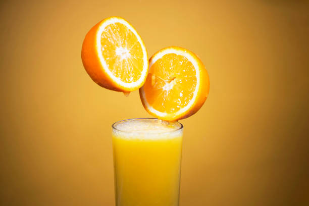 istock pouring juice into a glass from half an orange 1455979118