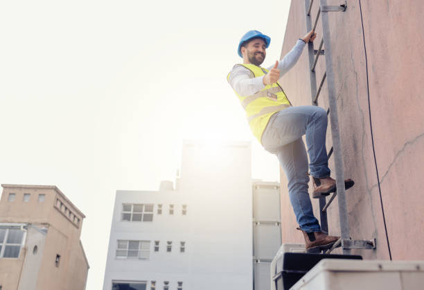 istock Engineer, ladder and thumbs up with man climbing on a building during construction inspection. Agree, approve and thumbsup with builder working on building architecture for maintenance and repair 1455979180