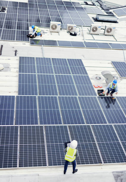 istock Solar panel, construction and industrial employees on roof for solar energy, engineering and sustainable lifestyle. Building, sustainability and teamwork for clean electricity and photovoltaic power 1455979198