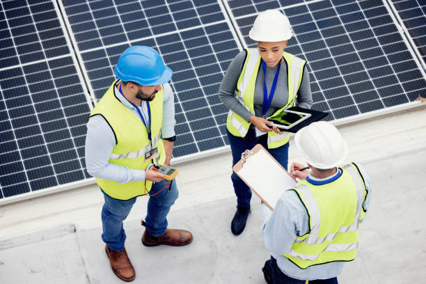 istock Top view, engineer teamwork and planning of solar panel maintenance, inspection or installation. Solar energy, renewable energy and group of contractors with tablet, tech or checklist in discussion. 1455979206