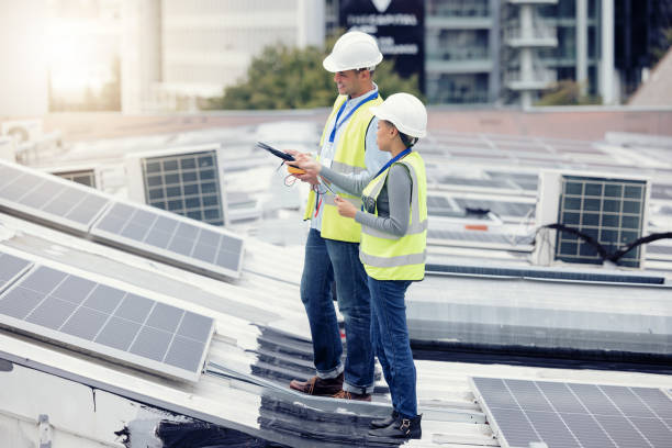 istock Sustainable engineering, solar panels and team doing maintenance on the rooftop of building in the city. Solar energy, ecology and industrial workers planning project with photovoltaic cells in town. 1455979252