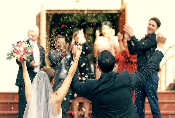 istock Wedding, applause and couple holding hands in celebration with support from clapping guests, friends and family. Back view, bride and groom celebrate trust, hope and success in love at a social event 1455979401