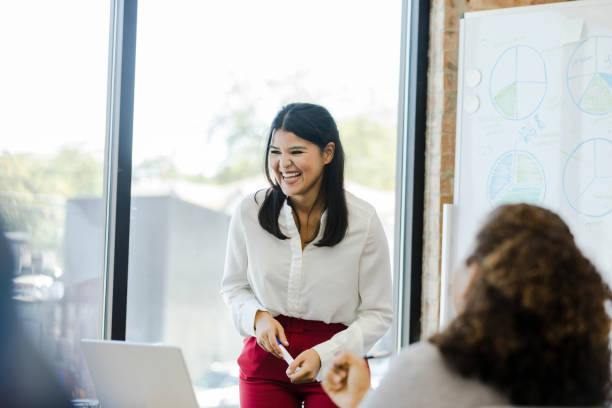 istock Employees share laugh during presentation at staff meeting 1455980061