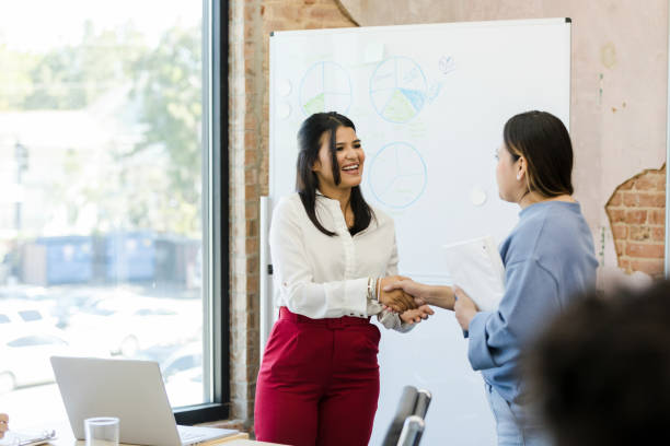 Female CEO shakes hands with female employee