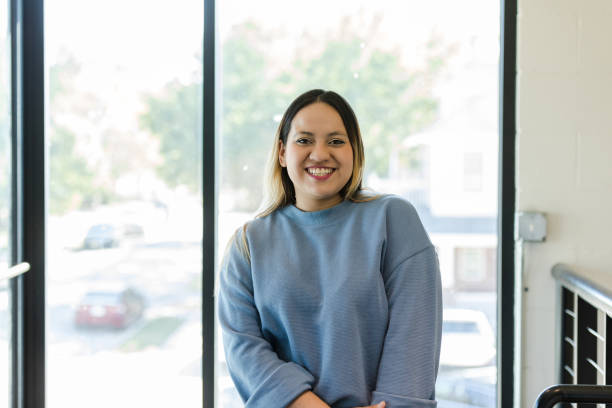 istock Casually dressed young adult teacher smiles for camera 1455980118