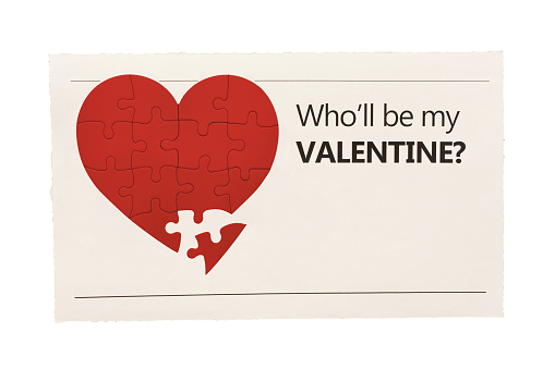 Simulated newspaper clipping featuring a photograph of a heart-shaped jigsaw puzzle with one missing piece, and a headline asking Who'll be my Valentine? Design and photo are by the photographer, so this image is free of third-party copyright and may be used without restrictions. Blank space for your copy.