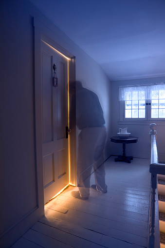 Behind closed bedroom doors. lights on behind door.  mysterious, privacy, ingtruder, break in.