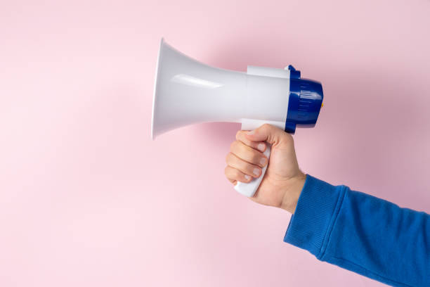 istock Megaphone in hand on bright background. Creative announcement concept. 1455991482
