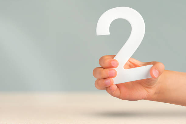 istock Number two in hand. Hand holding white number 2 on blurred background with copy space. Concept with number two. 2 percent, birthday 2 years old, couple, two, double 1455992411