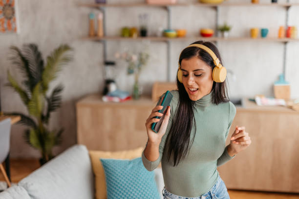 istock Young Woman Singing And Dancing At Home 1455992654