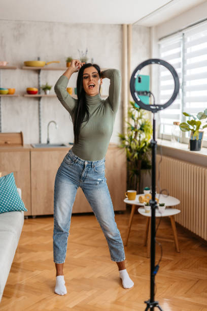 istock Young Woman Filming Herself Dancing Using Ring Light At Home 1455992697