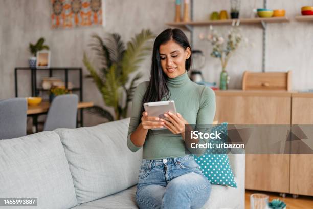 Young Woman Using Digital Tablet At Home Stock Photo - Download Image Now - Adult, Adults Only, Apartment
