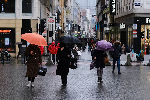 People walk in shopping district during a rainy day in Brussels, Belgium, on Jan. 12, 2023. Belgium's 2023 winter sales take place from January 3 to January 31.