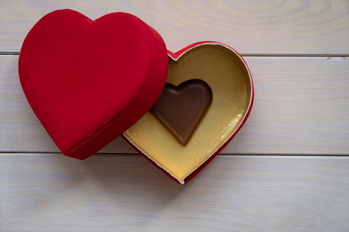 Heart shape chocolate and heart shape box on wood