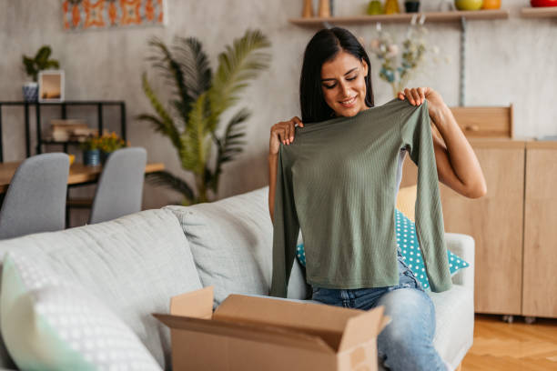 istock Young Woman Unboxing A Package With A New Sweater 1455994235