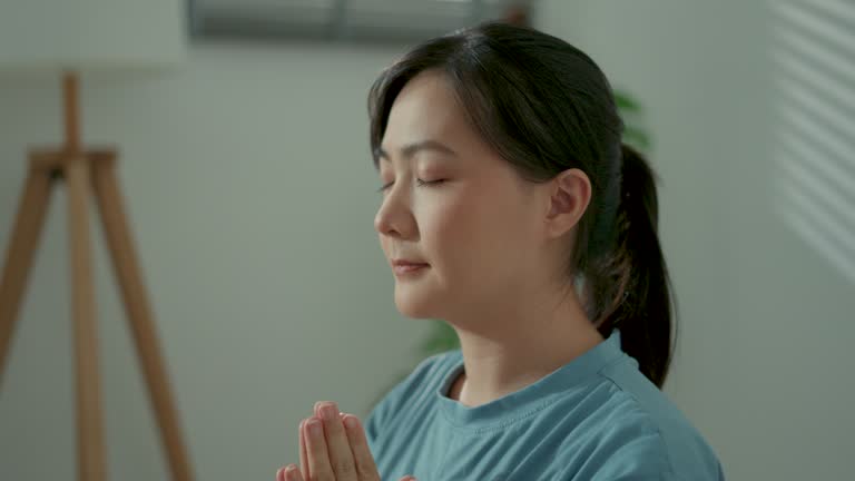 Close-up shot of woman closed eyes do meditation practice in living room at home.