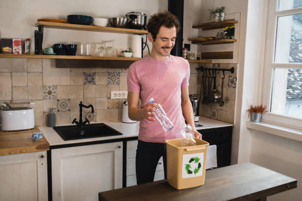 istock Young man collecting plastic bottles for recycling 1455997274